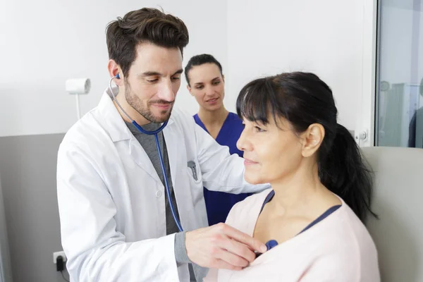 Médico de sexo masculino revisando a un paciente mayor usando estetoscopio —  Fotos de Stock