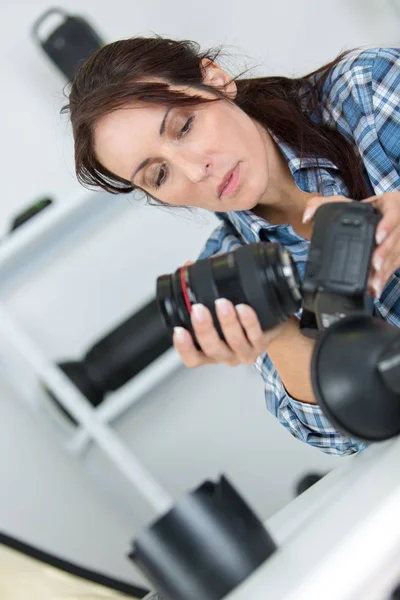 Kobieta fotograf sprawdza jej obiektyw — Zdjęcie stockowe