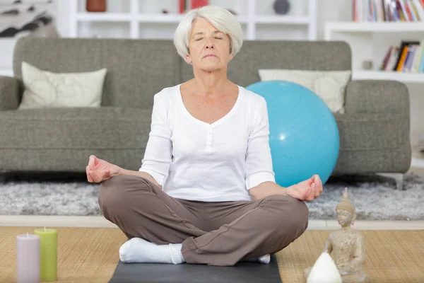 Madura dama haciendo yoga en casa — Foto de Stock