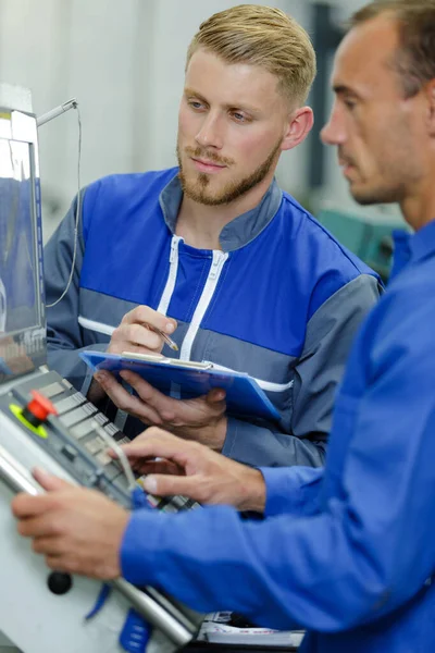 Men operating machines in factory — Stock Photo, Image