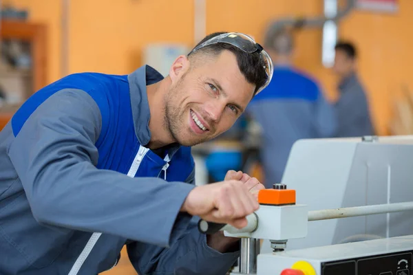 Un trabajador en fábrica en la máquina — Foto de Stock