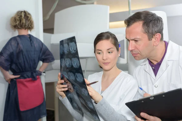 Radióloga mujer revisando rayos X con su compañero de trabajo —  Fotos de Stock