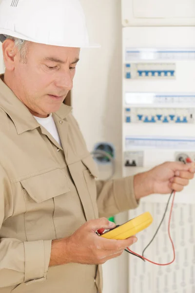 Costruttore di elettricisti al lavoro con tester di misurazione ad alta tensione — Foto Stock