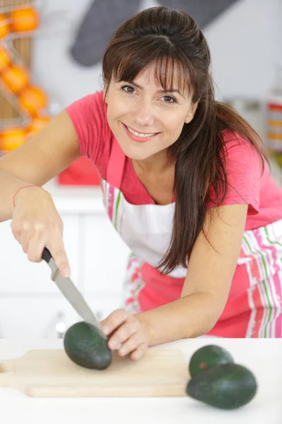 Donna taglio avocado in cucina — Foto Stock