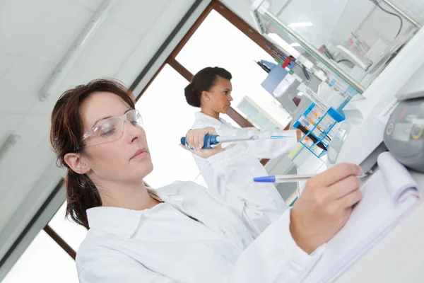 Relatório de escrita do trabalho feminino no laboratório — Fotografia de Stock