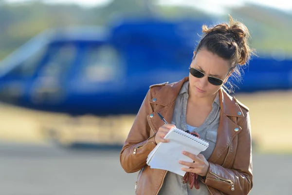 Vrouwelijke helikopterpiloot neemt nota — Stockfoto