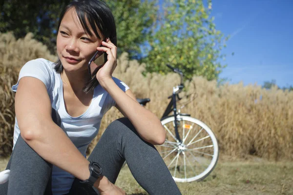 Una donna ciclista al telefono — Foto Stock