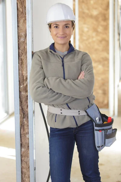 Mulher construtor posando ao lado de painel de isolamento de lã — Fotografia de Stock