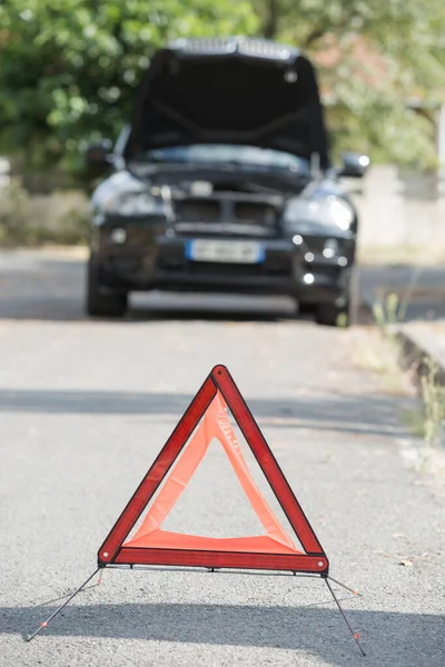 Red triangle of a car on the road — Stock Photo, Image