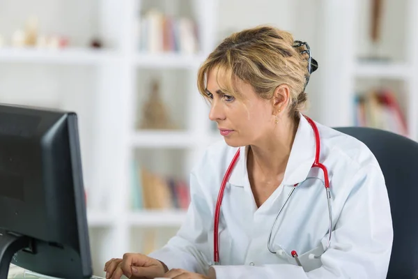 Vrouwelijke arts op zoek naar computer in het ziekenhuis — Stockfoto