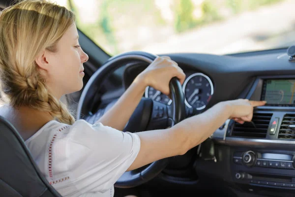 Kvinna slår på luftkonditionering i en bil — Stockfoto