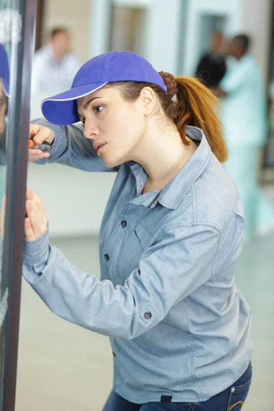 Frau schraubt Maschinenschrauben, um das Setup abzuschließen — Stockfoto