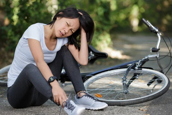 Jeune femme tombée du vélo dans la forêt — Photo