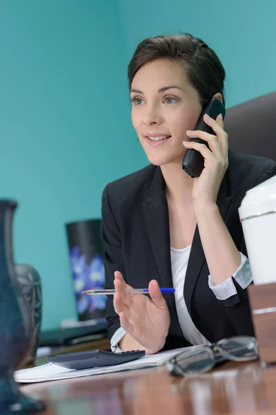 Žena s telefonem v kanceláři — Stock fotografie