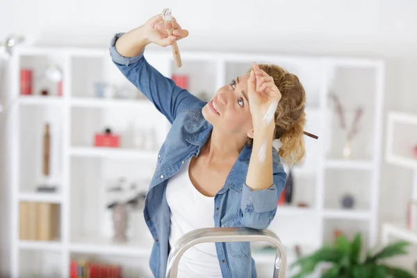 Eine Frau bemalt eine Wand — Stockfoto