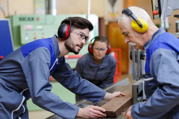 Porträtt av en industriarbetare med yngre personer — Stockfoto