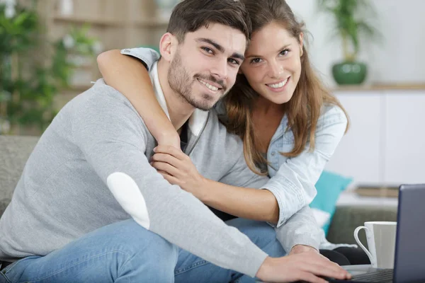 夫妻拥抱和坐在与笔记本电脑 — 图库照片