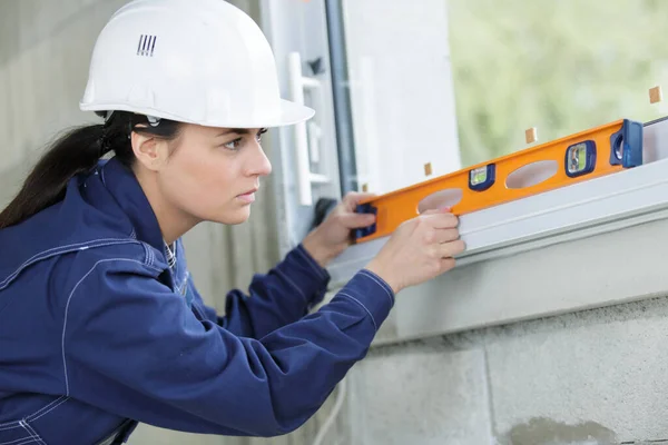 Female Worker Checks Level Window — Stock Photo, Image