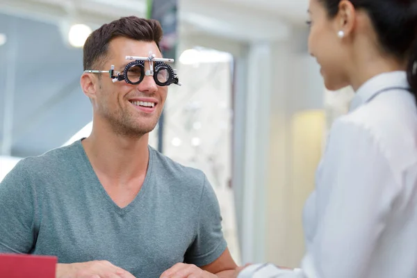 幸せな男性の目の検査をする女性光学者は — ストック写真