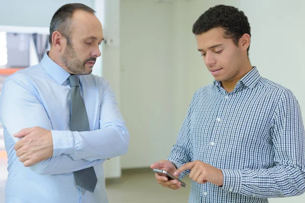 Jonge Man Met Behulp Van Smartphone Oudere Man Kijken — Stockfoto