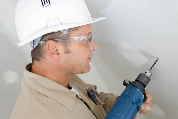 Ein Mann Hält Eine Bohrmaschine — Stockfoto