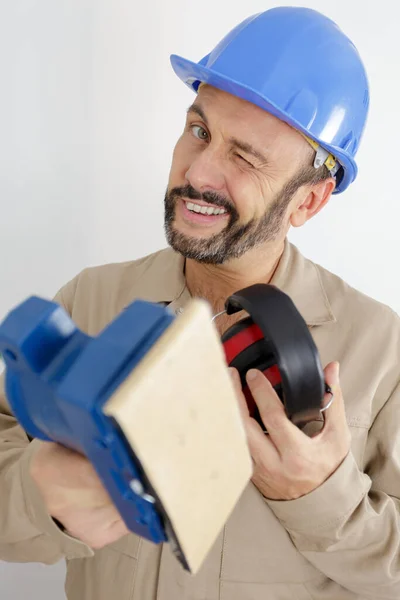 Comerciante Piscando Enquanto Segurando Lixadeira Equipamento Proteção — Fotografia de Stock