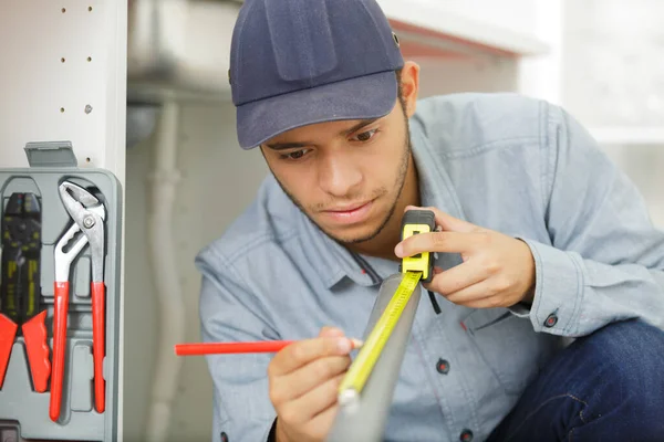 Young Tradesman Measuring Pvc Pipe — Stock Photo, Image