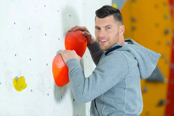 strength and sporty male climbing on an indoor climbing wall