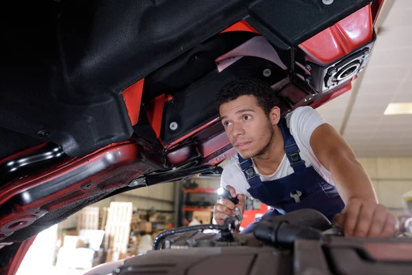 Joven Mecánico Masculino Inspeccionando Vehículo Industrial Con Antorcha — Foto de Stock