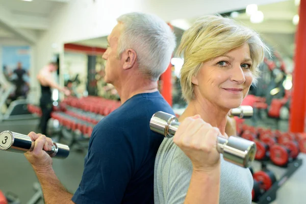 上了年纪的夫妻在健身房练举重 — 图库照片