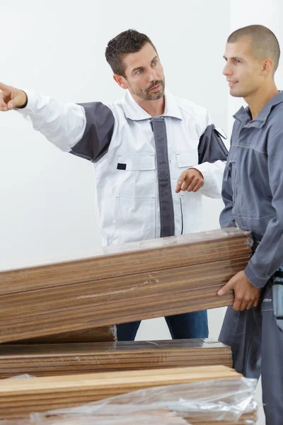 Carpinteiro Masculino Grave Mostrando Algo Para Colega Trabalho — Fotografia de Stock