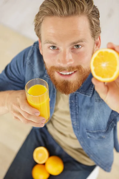 Schöner Mann Zeigt Eine Orange — Stockfoto