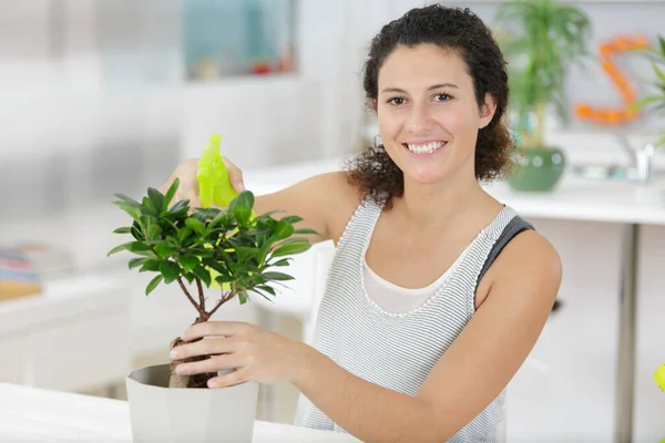 若い女性が盆栽を撒き — ストック写真