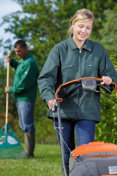 Kvinnlig Arbetstagare Som Använder Gräsklippare För Att Klippa Grönt Gräs — Stockfoto