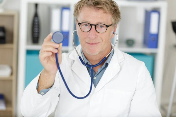 Bonito Médico Homem Mostrando Seu Estetoscópio — Fotografia de Stock