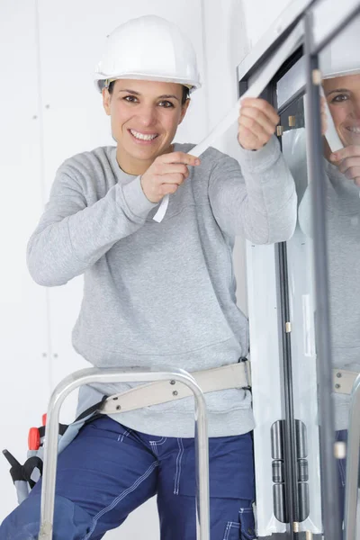 快乐的女建筑工人修理窗户 — 图库照片
