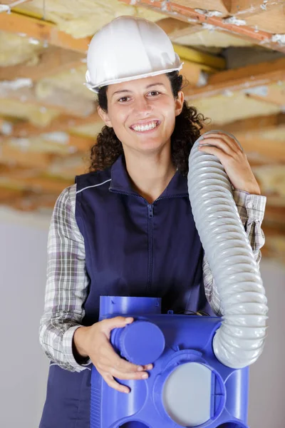 Happy Female Worker Holding Ventilation Pipes Indoors — Stock Photo, Image