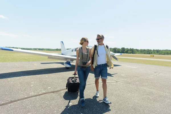 荷物を持って民間航空機から — ストック写真