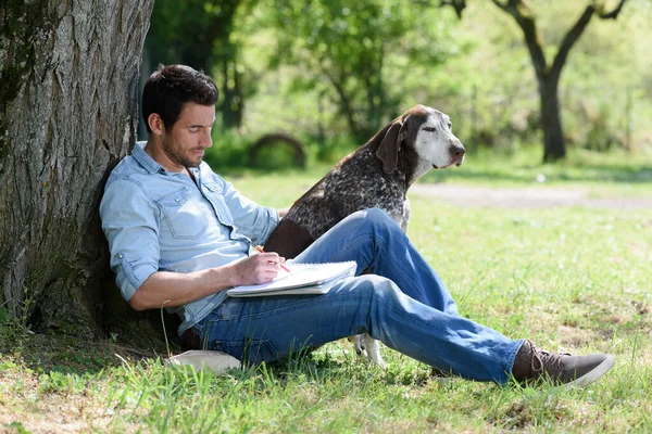 男子与狗与白色空白在绿色的公园草地上 — 图库照片