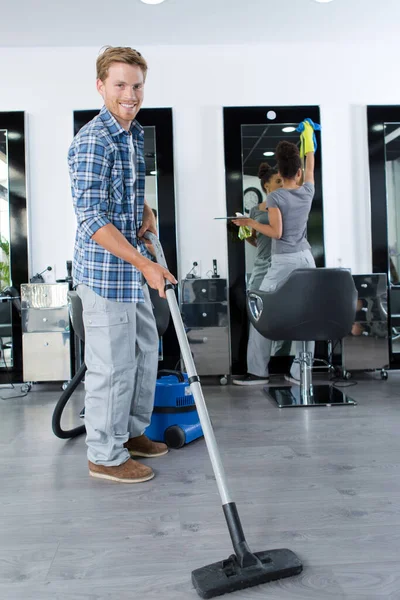 Νεαρός Άνδρας Που Σκουπίζει Πάτωμα Στο Σαλόνι — Φωτογραφία Αρχείου