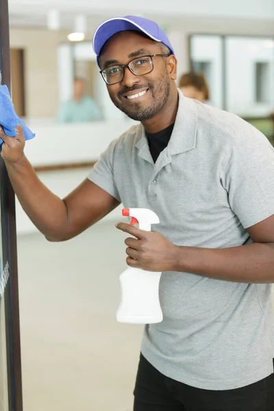 Junger Mann Putzt Fenster Büro — Stockfoto