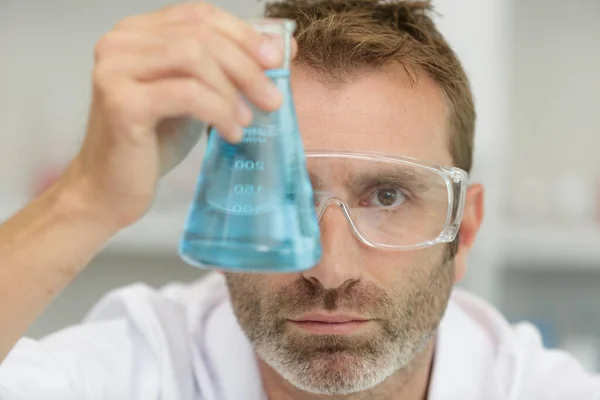 Mannelijke Wetenschapper Die Glazen Kolf Met Blauwe Vloeistof Onderzoekt — Stockfoto