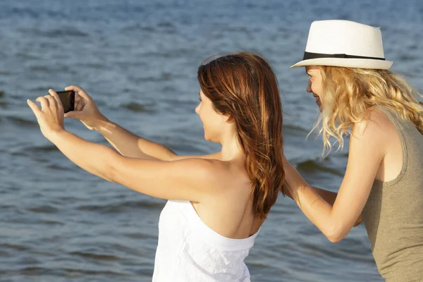 Zwei Junge Frauen Fotografieren Das Meer Mit Ihren Smartphones — Stockfoto