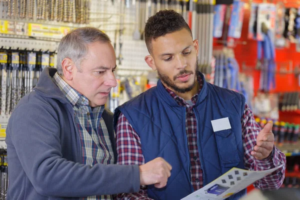 Deux Hommes Regardant Travers Catalogue Dans Quincaillerie — Photo