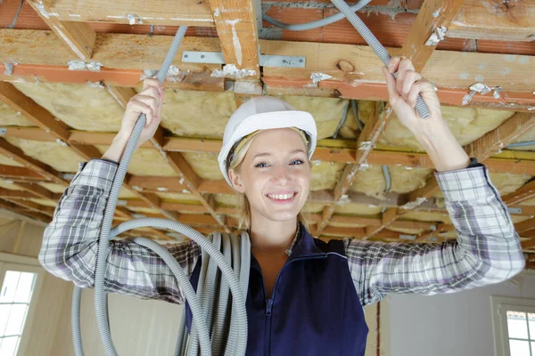 安装电缆导管的女建筑工人 — 图库照片