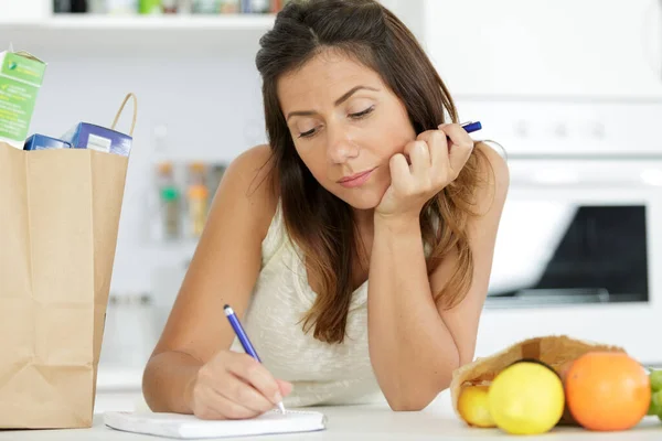 Mulher Cozinha Com Compras Escrevendo Caderno — Fotografia de Stock