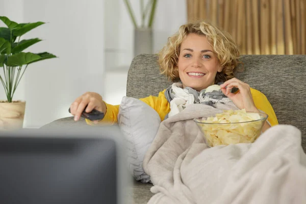 テレビを見ているポテトチップスを食べた女性 — ストック写真