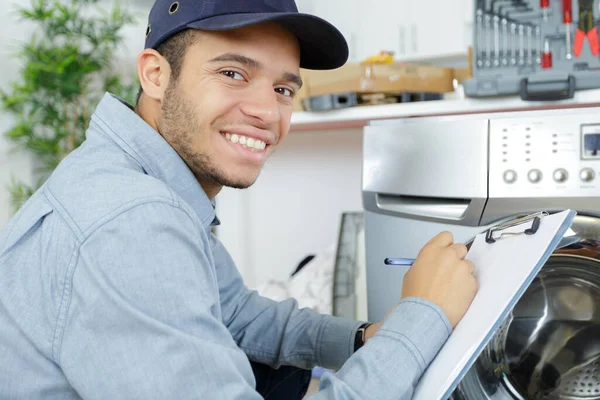 plumber with clipboard near washing machine