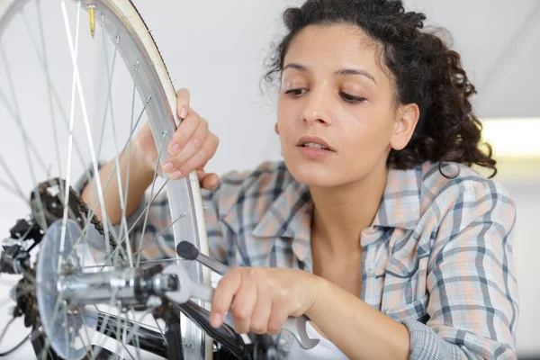 美しい女性の締め付け自転車ホイールネジ — ストック写真