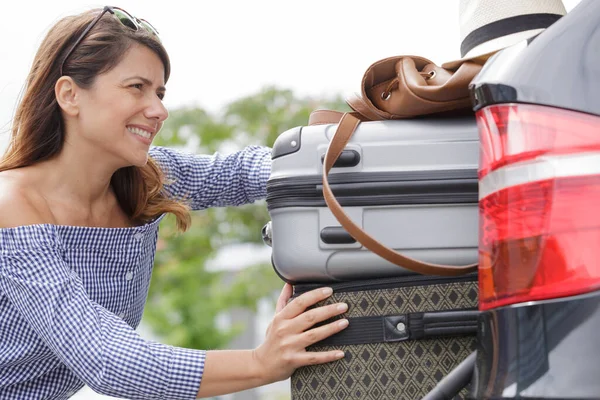 Donna Che Lotta Spingere Bagagli Nel Bagagliaio Auto — Foto Stock